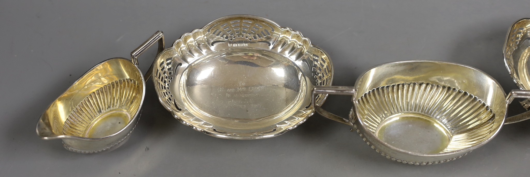 A George V demi fluted silver cream jug and sugar bowl, Birmingham, 1911 and a pair of pierced silver bonbon dishes, Birmingham, 1928, 8oz.